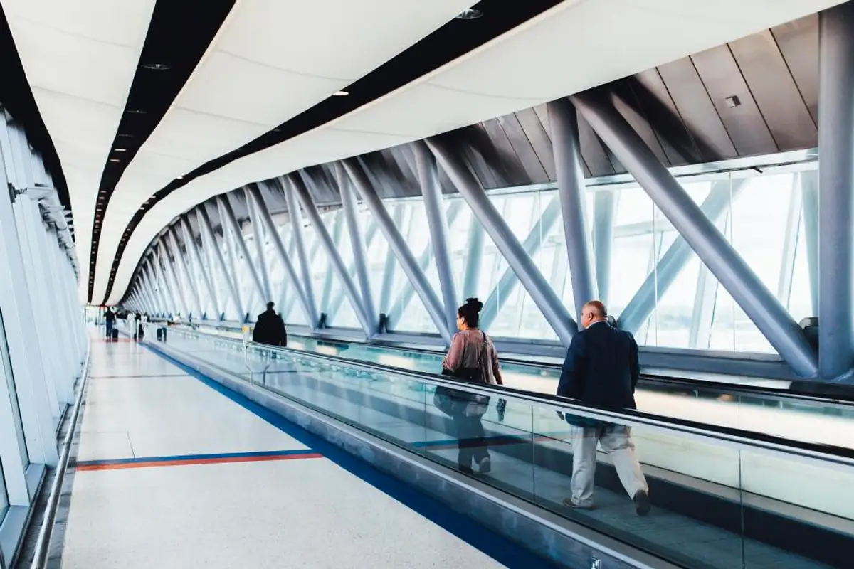 Voyageur avec valise et smartphone dans un hall d’aéroport