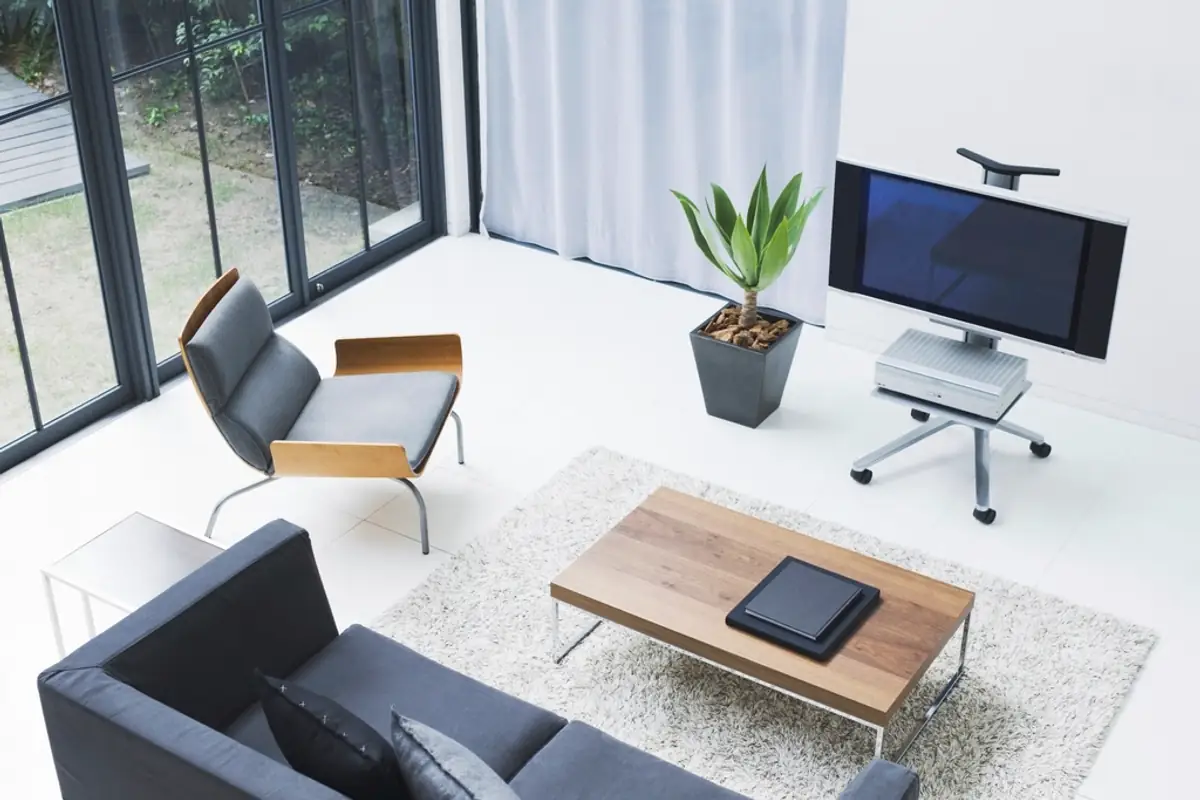 Salon moderne avec téléviseur sur pied, canapé et table basse